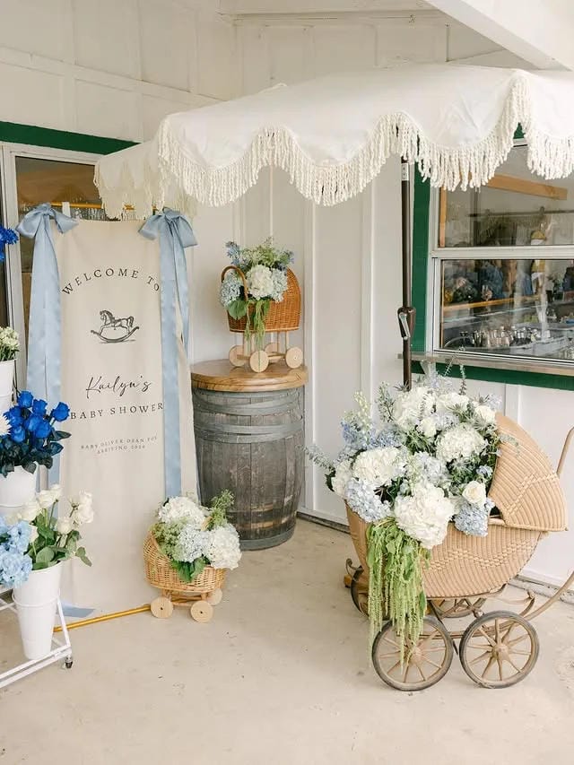 boy baby shower welcome area with baby carriage flowers