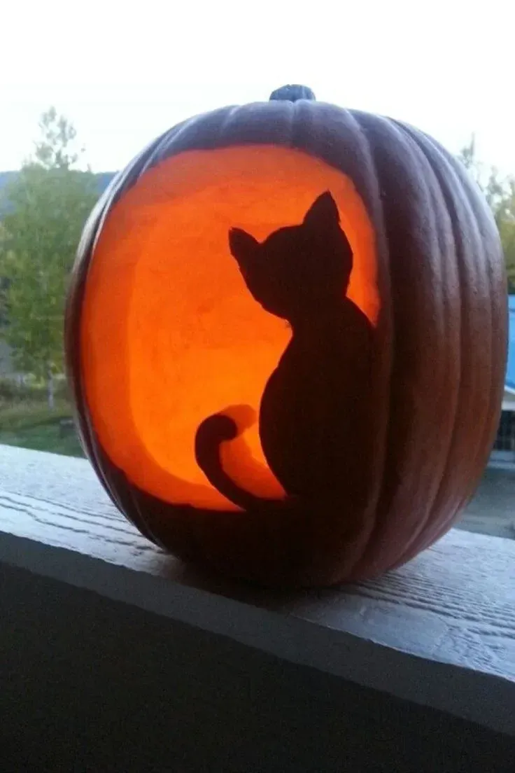 kid friendly pumpkin carving ideas with black cat silhouette, glowing pumpkin, and simple Halloween cat design
