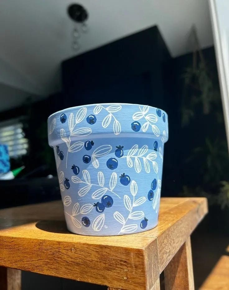 painted flower pot idea with blue berry pattern leaves and floral details