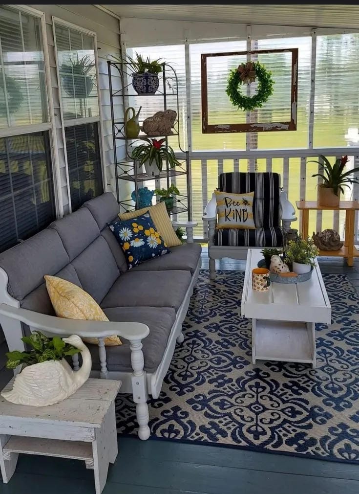 screened in porch decorating ideas with blue patterned rug gray sofa wreath and yellow pillows