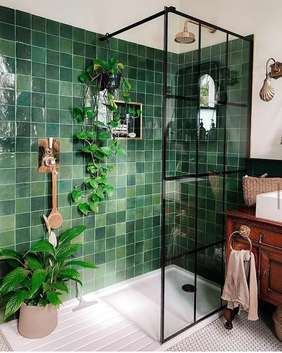green bathroom ideas with emerald shower tile, glass screen, plants, black trim, and wood vanity