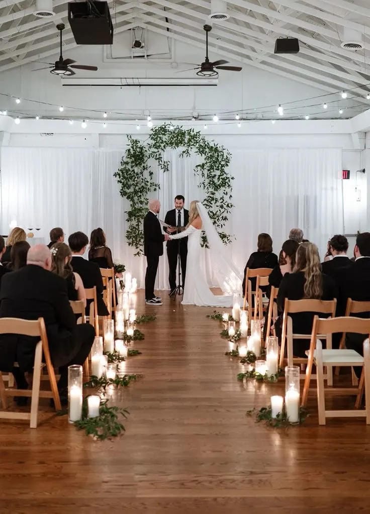 wedding aisle decor with floral pillars and petals
