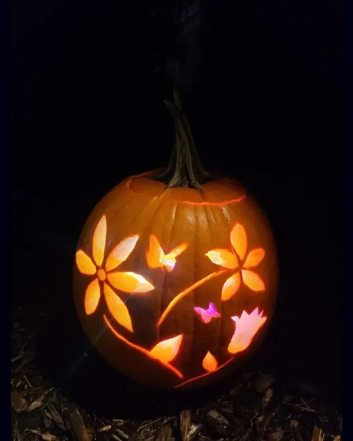kid friendly pumpkin carving ideas with flower cutouts, glowing petals, and pretty pumpkin design
