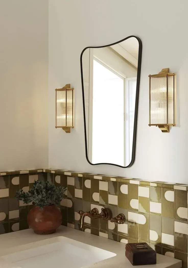 unique bathroom decor with olive checkerboard tile arched mirror and warm sconces