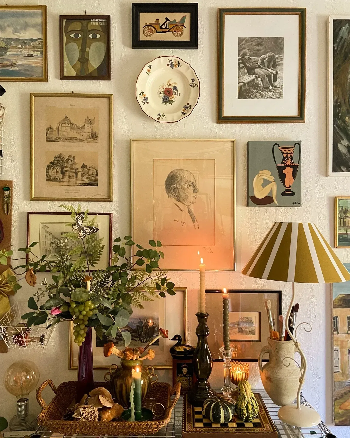 entryway vintage home decor ideas with gallery wall, striped lamp, books, and small table
