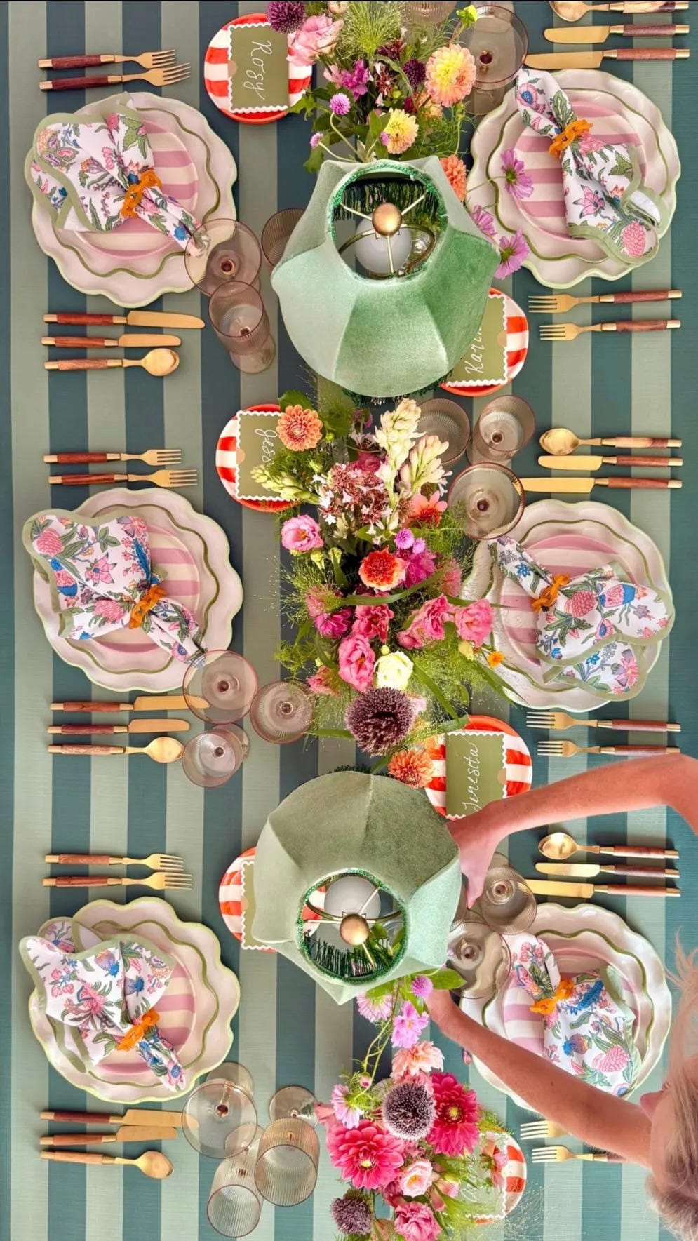 fall tablescape ideas with green striped tablecloth pink plates fruit and colorful flowers