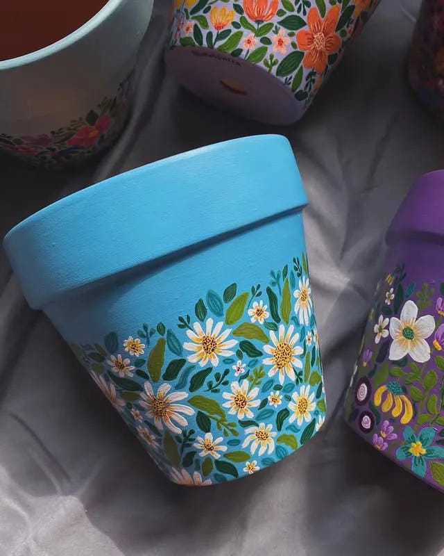 painted flower pots with blue daisy design and little bee details