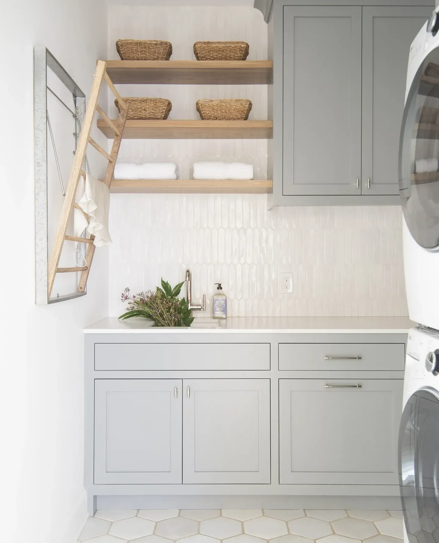 small laundry room ideas with drying ladder, open shelves, baskets, towels, cabinets, and washer dryer