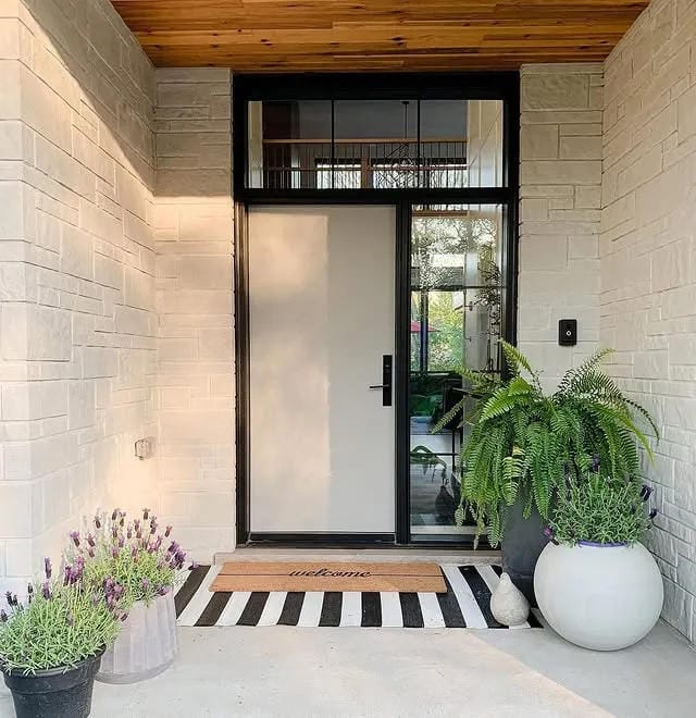 small front porch ideas with large white fern planter striped doormat and modern black door