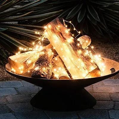 outdoor string light ideas with add glow beside a fire bowl