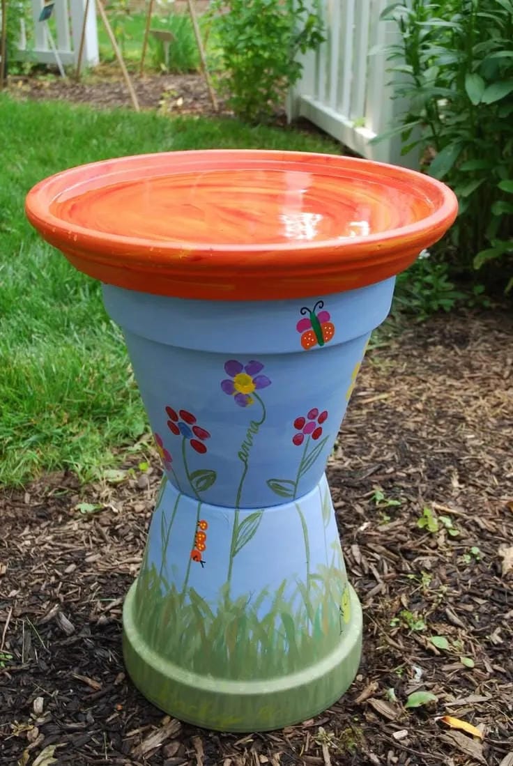 DIY bird bath idea with painted terracotta pedestal and orange saucer