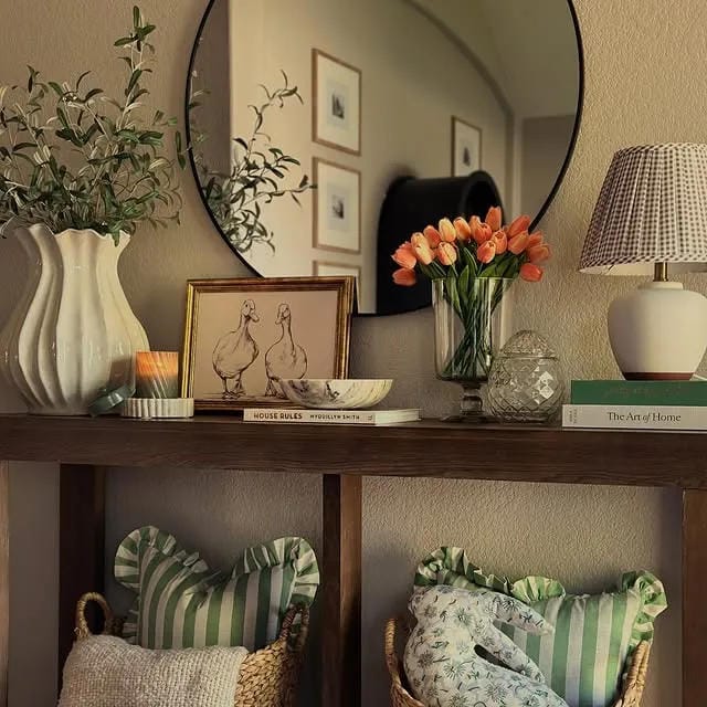entryway table decor with round mirror lamp flowers artwork pillows and baskets