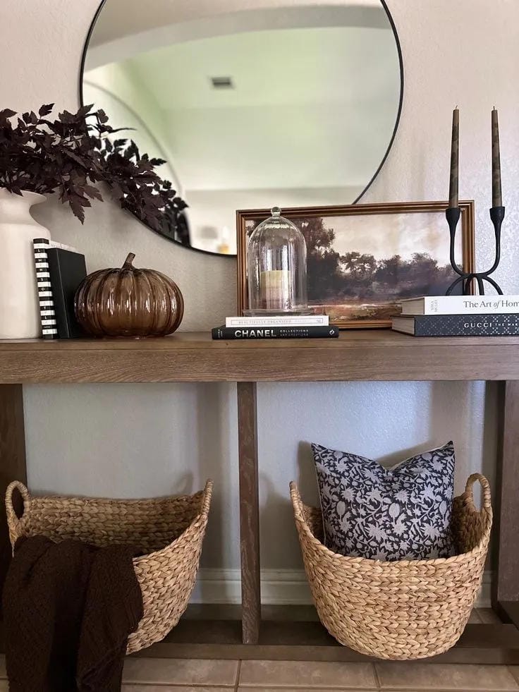 fall entryway table decor ideas with glass pumpkins, fall branches, black candlesticks, basket, mirror, and console table