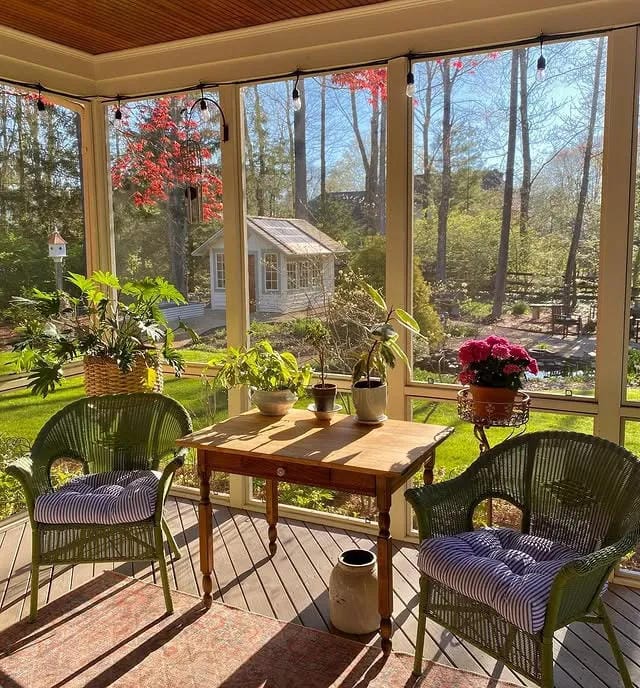 screened in porch decorating ideas with green chairs wood table plants and forest view