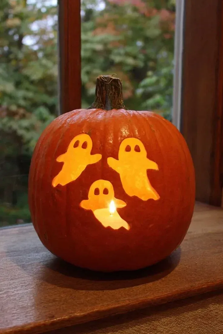 kid friendly pumpkin carving ideas with cute ghost cutouts, glowing shapes, and simple Halloween pumpkin design