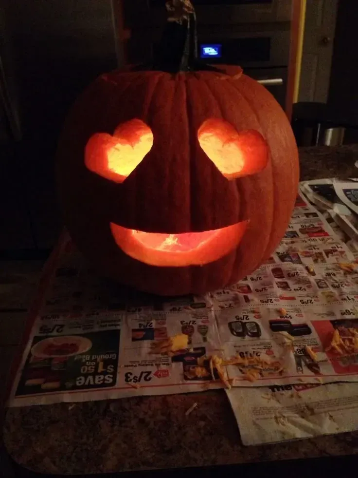 kid friendly pumpkin carving ideas with heart eyes, glowing smile, and cute pumpkin face