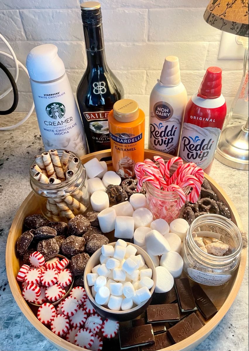 hot cocoa bar ideas with jars of toppings and a festive Christmas drink station