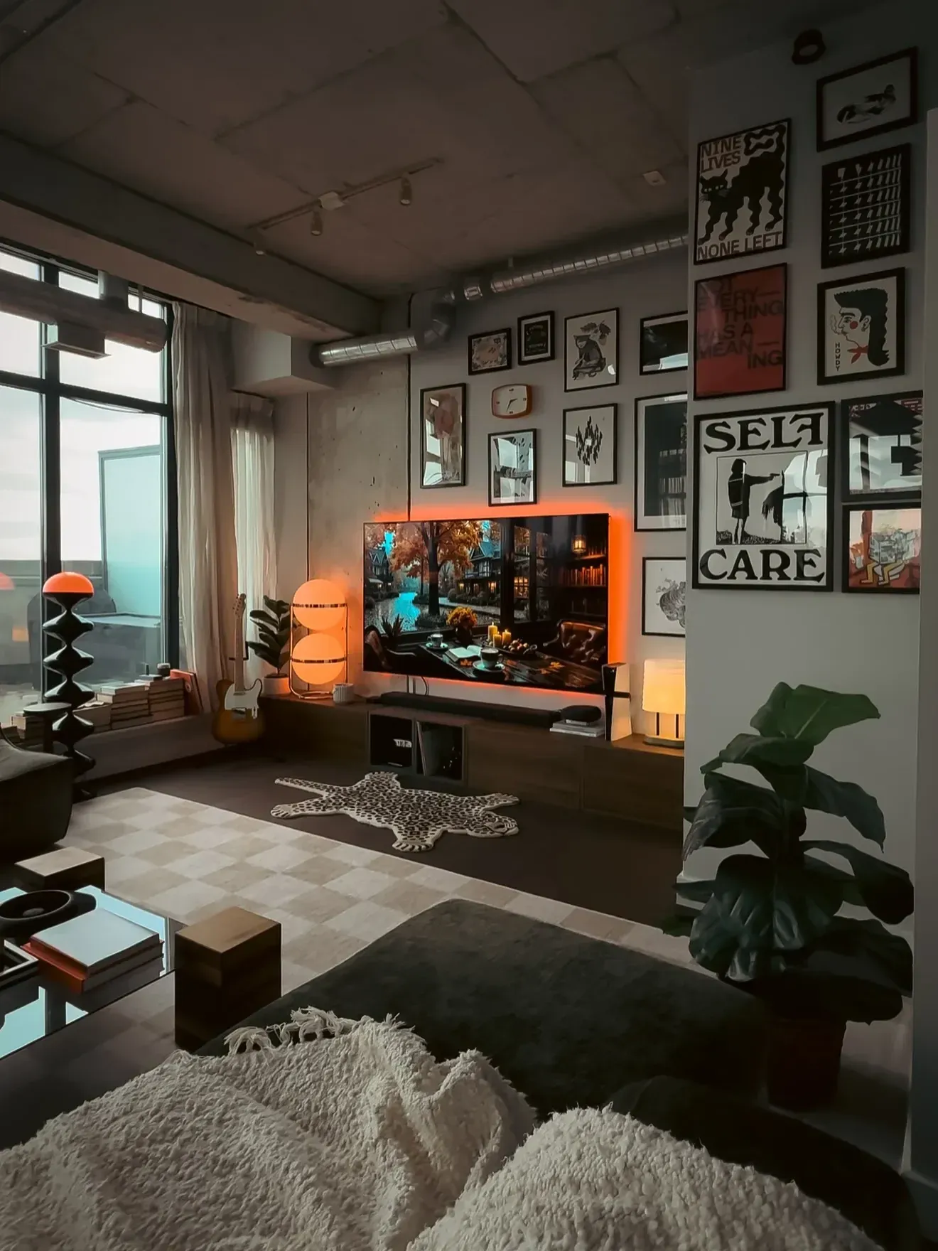 moody living room ideas with dark media wall, gallery art, orange lamp, and low seating