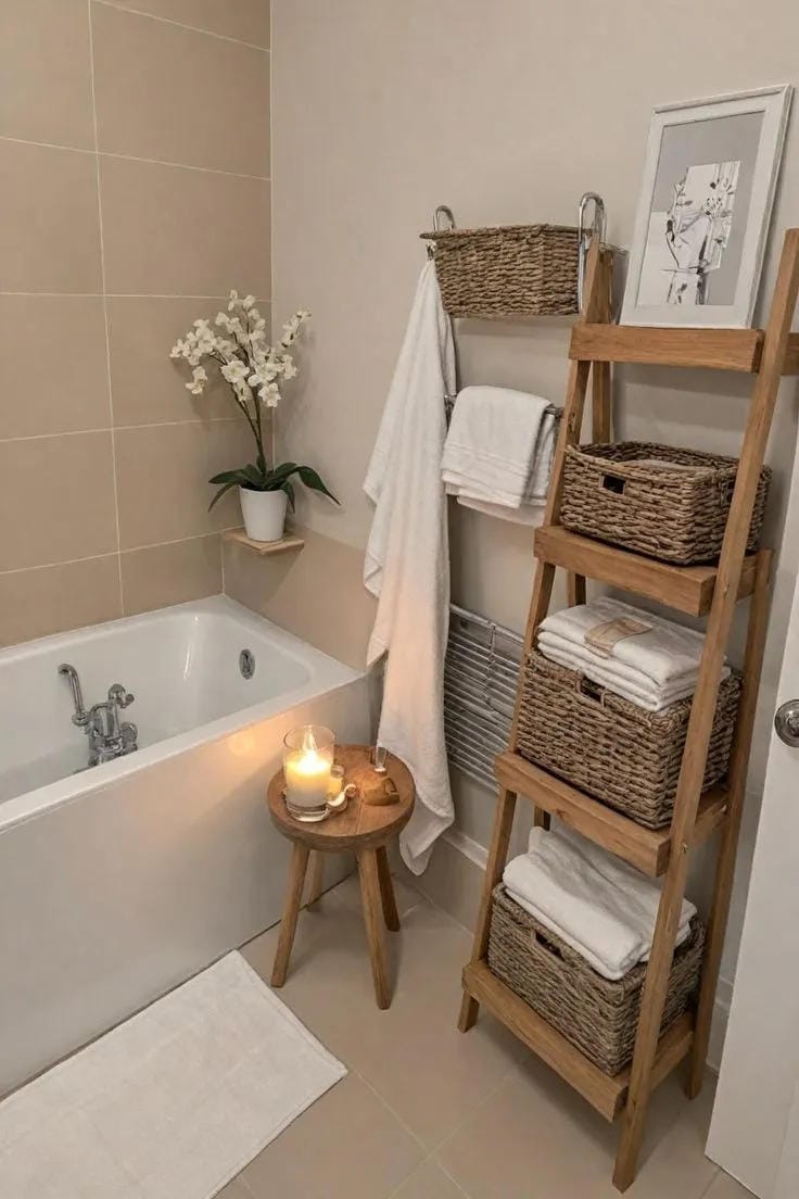 bathroom ladder shelf decor with towels baskets framed art flowers and candle by bathtub
