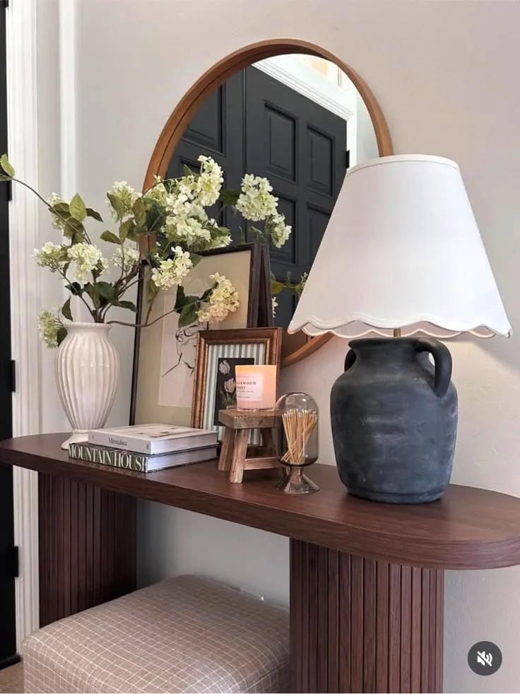 entryway table decor with lamp white flowers books frame and round mirror