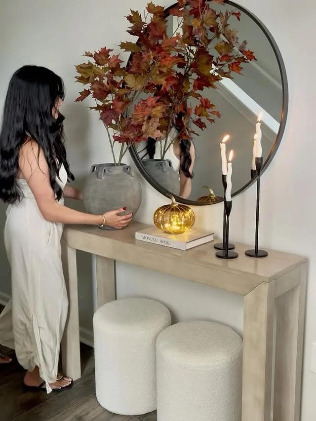 fall entryway table decor with large branches candles mirror and ottomans