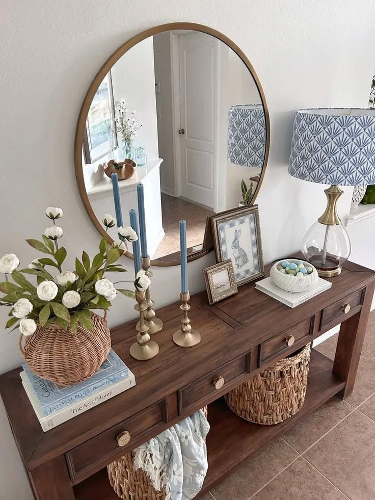 entryway table decor with round mirror candlesticks flowers and woven basket