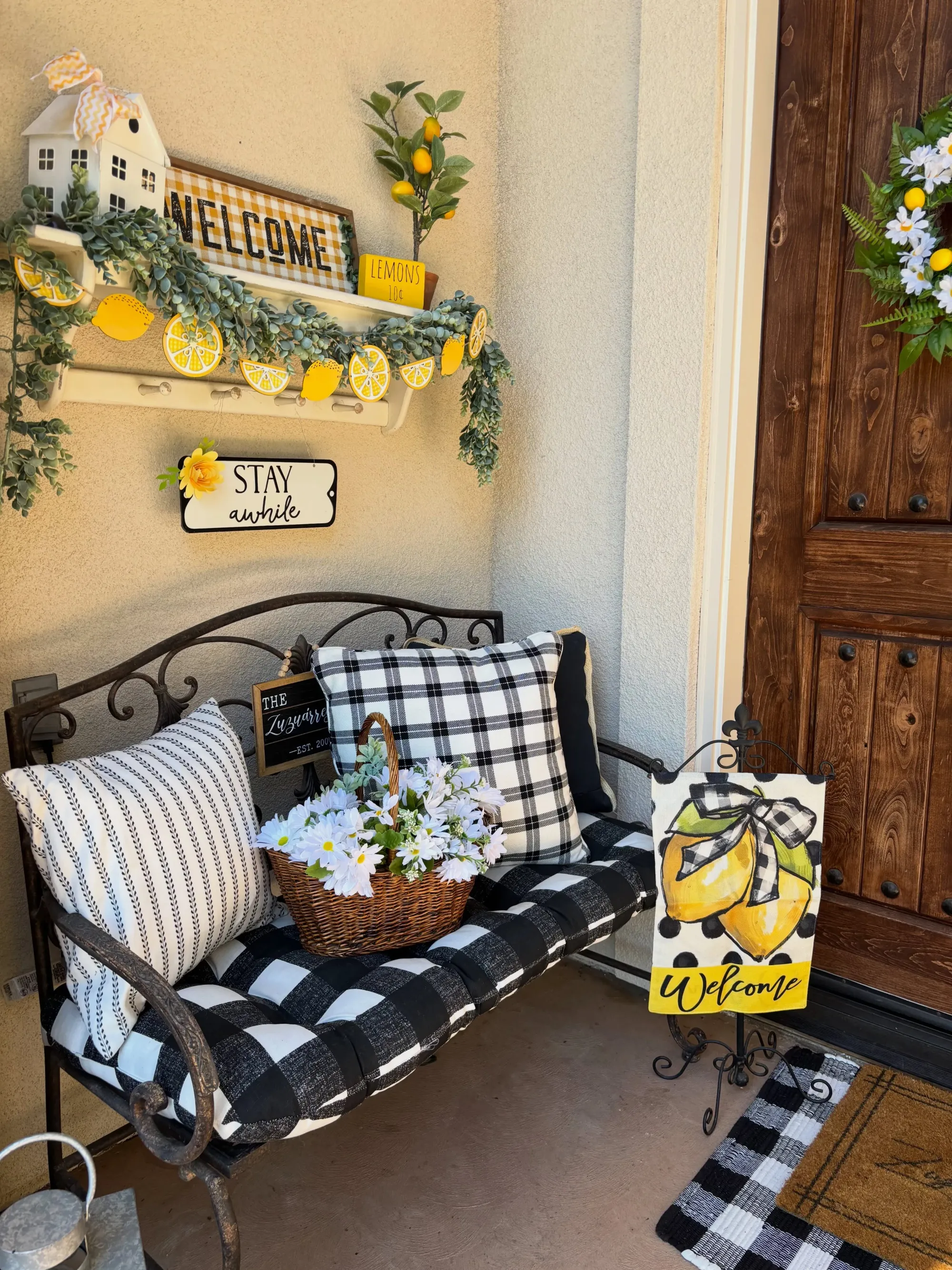 summer back porch decor ideas with black and white bench, lemon garland, yellow accents, and summer porch styling