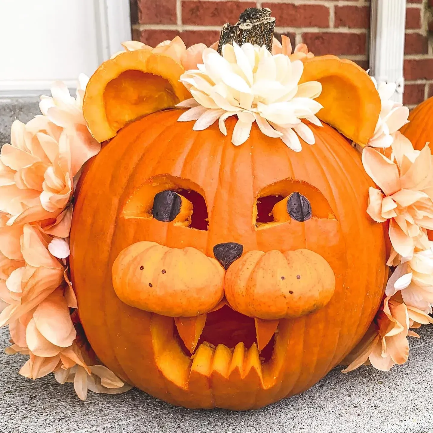 kid friendly pumpkin carving ideas with lion pumpkin, flower mane, carved face, ears, and cute animal design