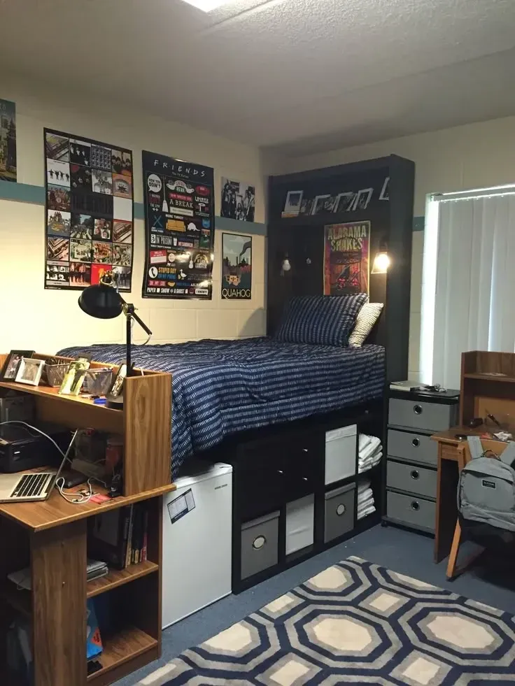 dorm decorating ideas for guys with lofted bed, storage cubes, bookshelf, desk, posters, and blue bedding