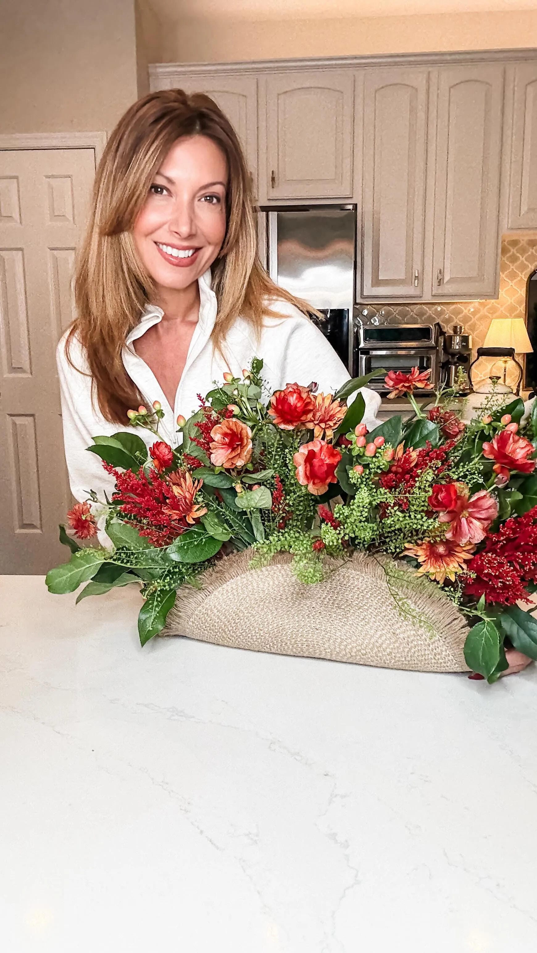 fall flower arrangement ideas with a long red and green floral centerpiece on a kitchen counter