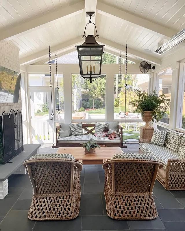 screened in porch decorating ideas with matching wicker chairs lantern and gray tile floor