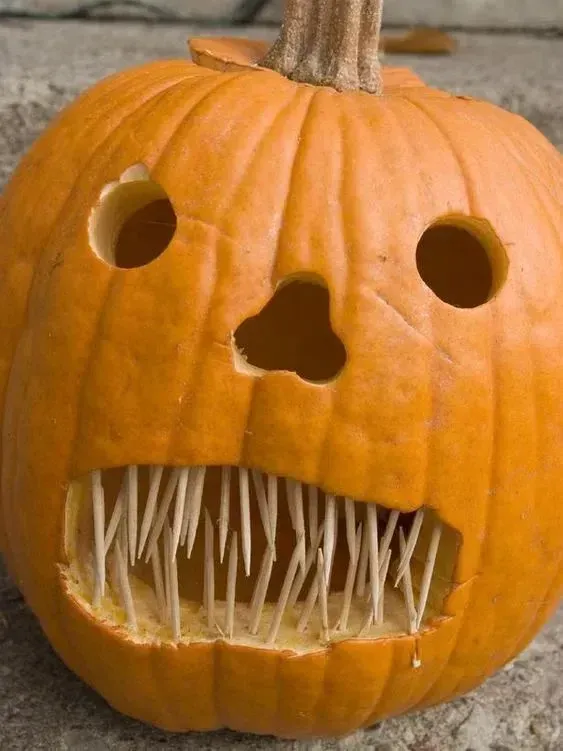 kid friendly pumpkin carving ideas with monster mouth, round eyes, toothpick teeth, and funny scary face