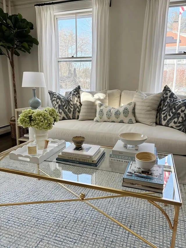 coffee table decor ideas with multiple stacks of books white tray flowers bowl and glass table