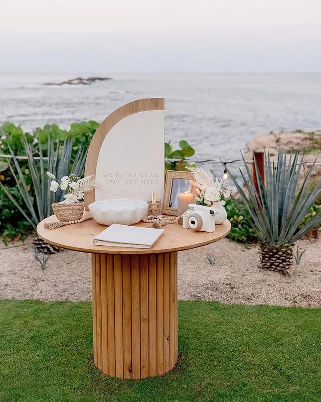 wedding welcome table with candles flowers and photos