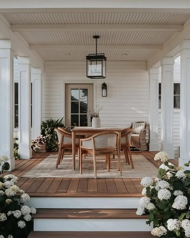 covered porch ideas with wood dining table white flowers and covered entry