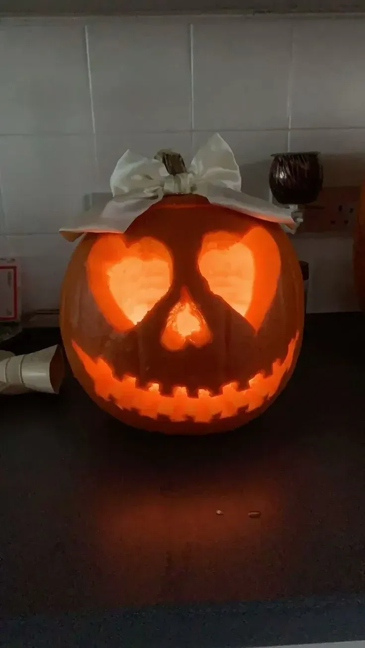 kid friendly pumpkin carving ideas with peace sign pumpkin, simple glowing face, and cute bow
