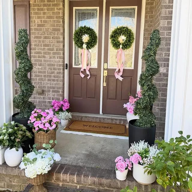 small front porch ideas with double door wreaths topiary planters pink flowers and black pots