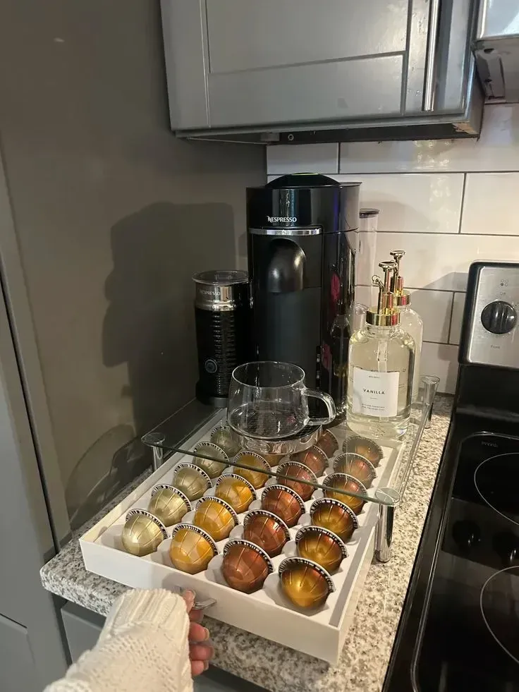 coffee station ideas with Nespresso machine, pull-out pod drawer, syrup bottle, and glass mug