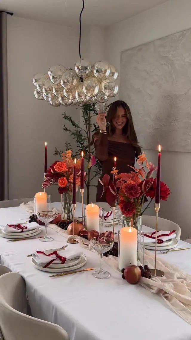 fall tablescape ideas with red flowers taper candles and simple white place settings