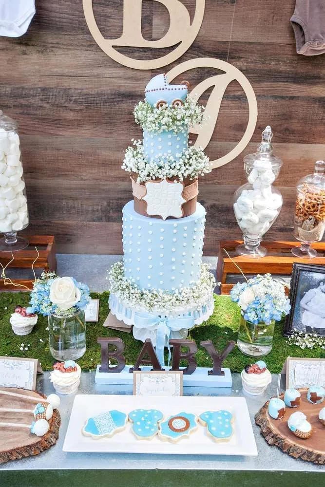 light blue boy baby shower cake display with rustic wood backdrop