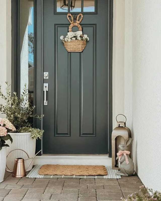 small front porch Easter decor with bunny basket potted flowers lantern and seasonal door basket