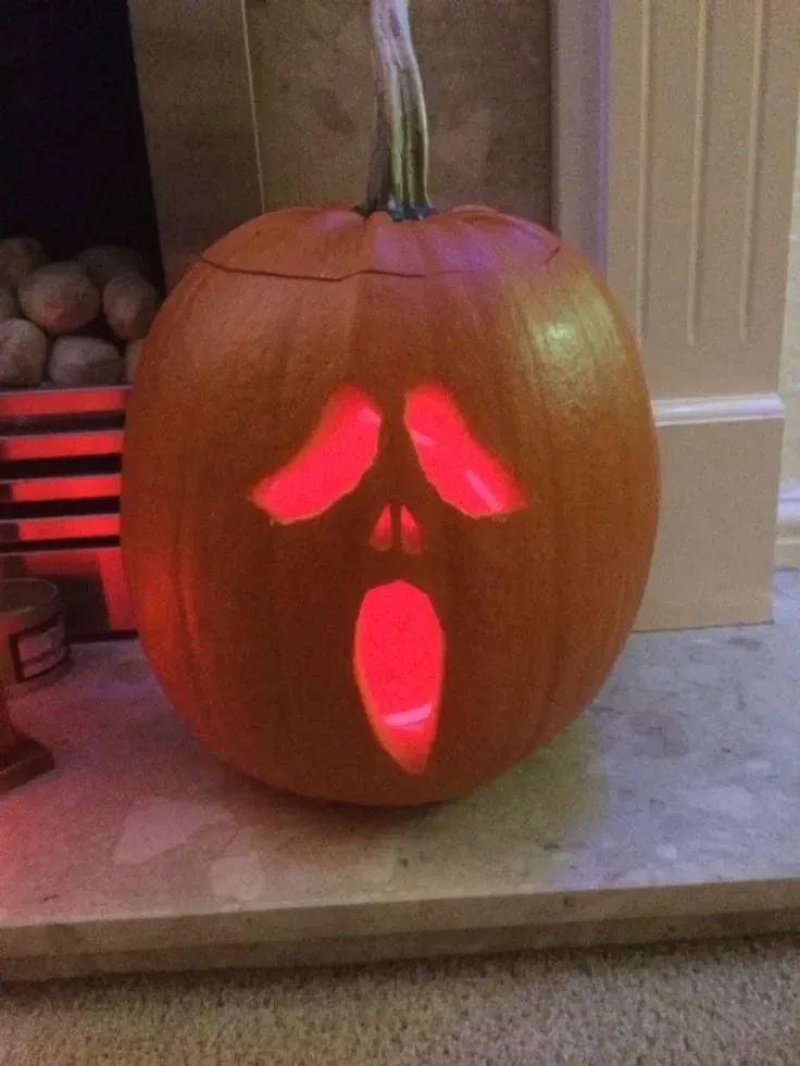 kid friendly pumpkin carving ideas with silly spooky face, glowing eyes, and open mouth