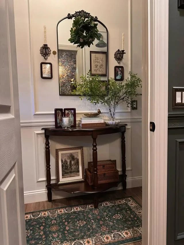 small entryway table decor with wreath lamp framed art and greenery