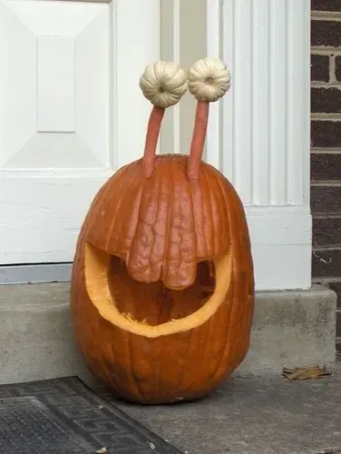 kid friendly pumpkin carving ideas with snail pumpkin, tall eye stalks, big smile, and cute animal design