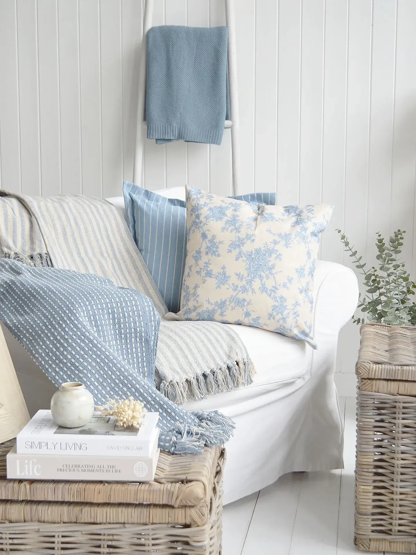 small coastal living room ideas with blue pillows, pale curtains, white sofa, and woven texture