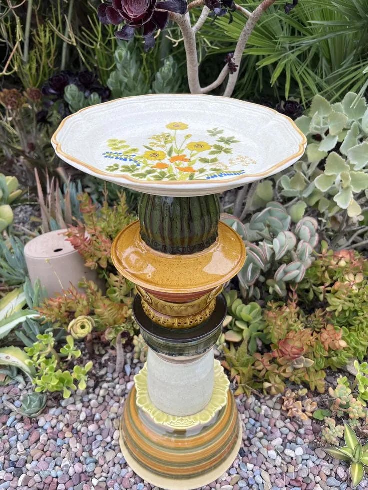 DIY bird bath idea with stacked thrifted bowls in a succulent garden