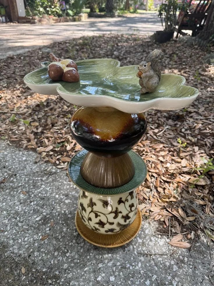 DIY bird bath idea with stacked ceramic bowls, leaf dish, squirrel, and acorns