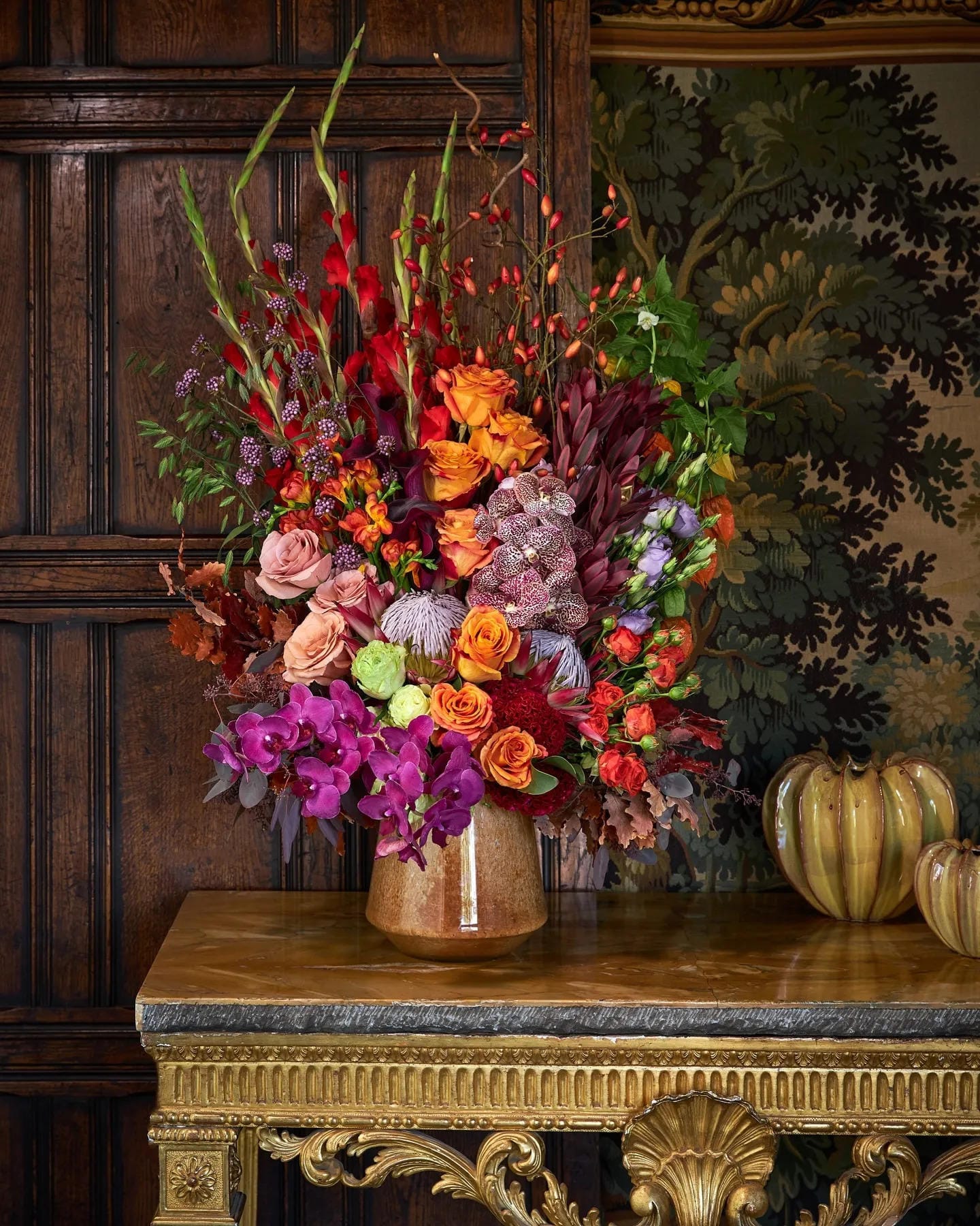 fall flower arrangement ideas with tall orange pink and burgundy flowers on an antique table