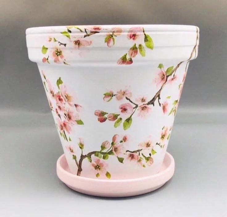 painted flower pot idea with white base pink floral vine pattern and matching saucer