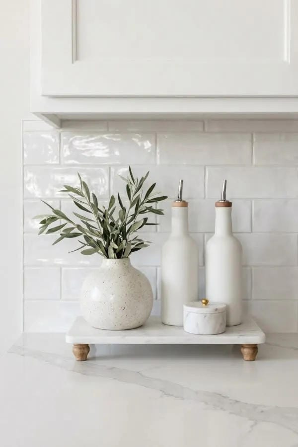 minimal kitchen counter decor with white tray olive branches candle and soap bottle